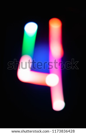 Digit 4. Four. Glowing numbers on dark background. Abstract light painting at night. Creative artistic colorful bokeh. New Year. Use it for build you own design for book cover, poster or post card.