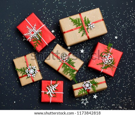 Christmas handmade red gift boxes and craft paper on dark background top view. Merry christmas greeting card. Happy New Year. Flat lay.