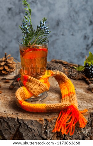 Mulled wine hot steaming drink with citrus, applem berries and spices on on a wooden stump selective focus