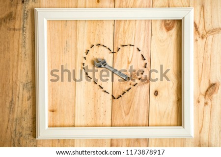 old white frame Vintage frame with varied tools with heart shape on wooden background