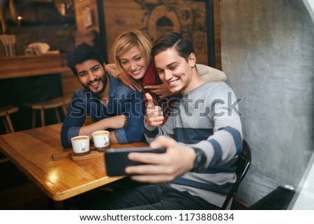 Friends Taking Photos On Phone In Cafe. Happy People Making Video Call, Having Fun Together. High Resolution