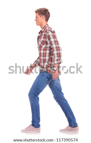 full length side view picture of a casual young man walking forward, isolated on white