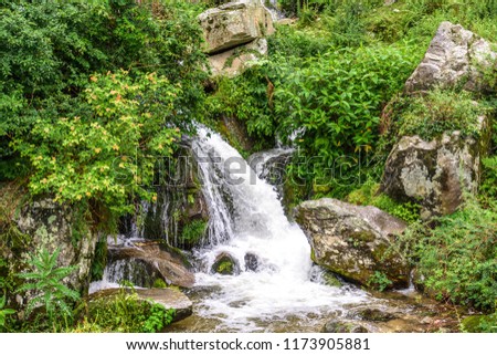 Waterfall flowing through lush green mountain. Mountain river waterfall landscape. Waterfall river scene