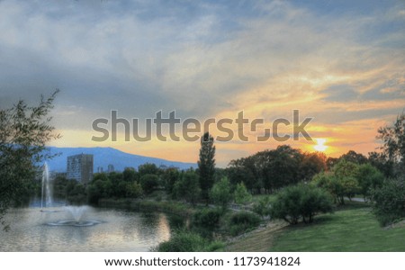 A colorful sunset over the city lake with buildings in the distance