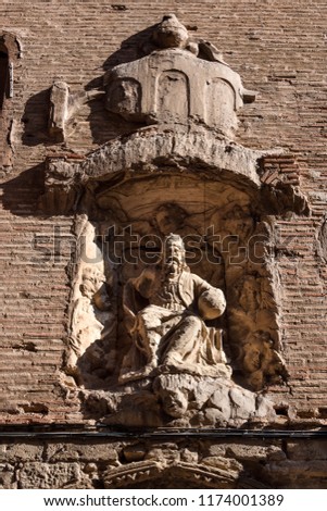 Spain, Puente La Reina: Mural relief on an exterior red brick wall in the narrow streets of the famous old Spanish small town literally named 'Bridge of the Queen' - concept history religion travel