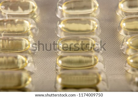 Yellow color vitamin pills softgels with omega 3 , epa and dha . Fish oil capsule pils close up background Royalty-Free Stock Photo #1174009750
