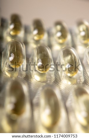 Yellow color vitamin pills softgels with omega 3 , epa and dha . Fish oil capsule pils close up background Royalty-Free Stock Photo #1174009753