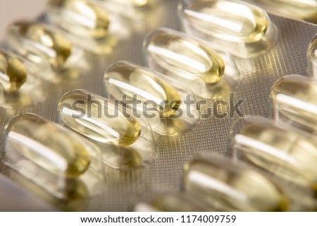 Yellow color vitamin pills softgels with omega 3 , epa and dha . Fish oil capsule pils close up background Royalty-Free Stock Photo #1174009759