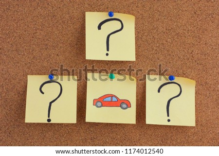 Car Questions. Post it notes with car and question marks on bulletin board. Close up.