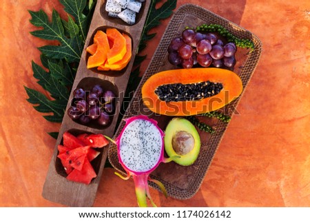 Tropical fruits on wooden platters from above. Healthy breakfast.