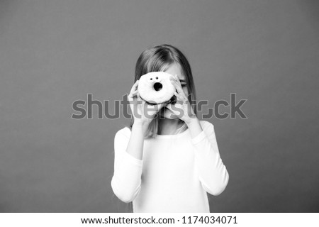 Sweet mood. Child look in donut on violet background. Little girl with glazed ring doughnut on purple background. Kid with junk food. Food and dessert. Childhood and childcare, copy space.