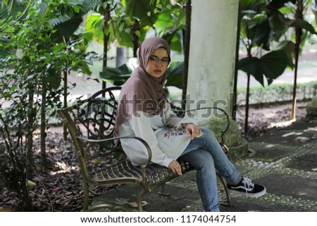Young cute hijab fashion hijab posing and expression with greenery background.