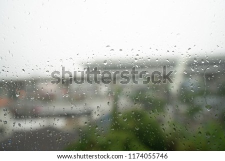 Water drops on a window glass during the rain fall. The sky trian railway is on background is blur.