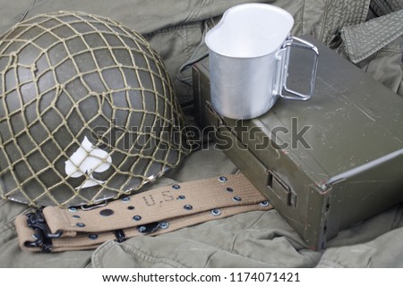 a cup of coffee with ww2 period us army military equipment on green uniform background concept