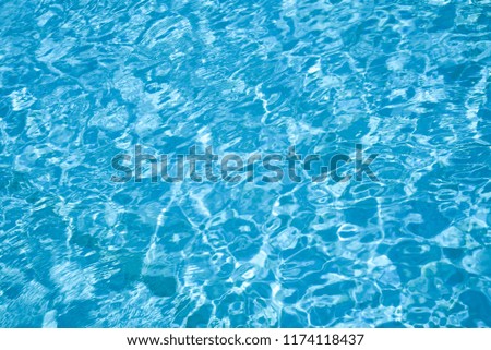 Ripple water in swimming pool with sun reflection