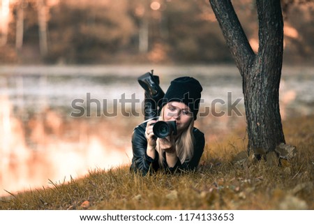 Portrait of a photographer covering her face with the camera. 