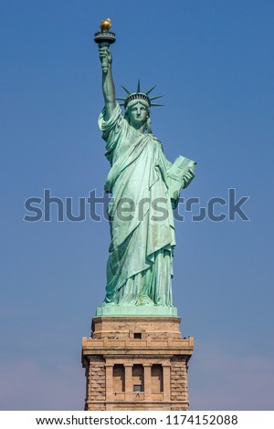 A view of the Statue of Liberty in New York, with a clear blue sky behind