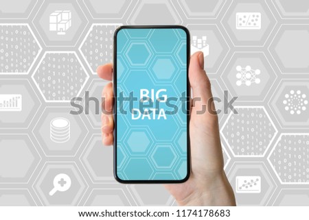 Big data concept. Hand holding modern bezel-free smartphone in front of neutral background with icons