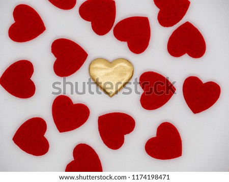 Single golden heart in the middle of red hearts
