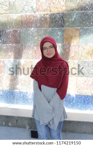 cute east Asian girl posing around while fixing her hiijab