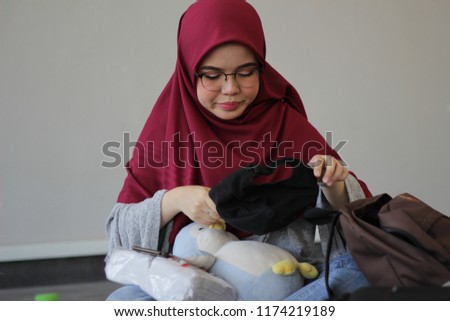 cute east Asian girl posing around while fixing her hiijab
