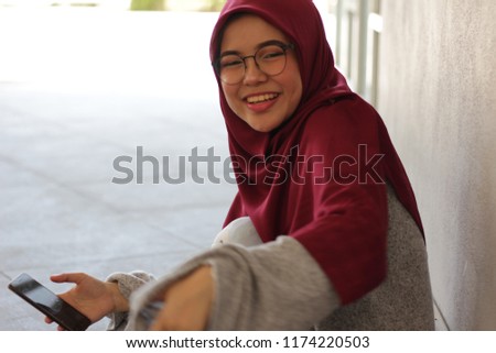 East Asian university girl wearing hijab is reading some books for a test.
