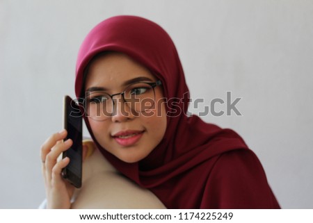 Young cute Asian hijab girl using phone to connect with other people for various task such study and business