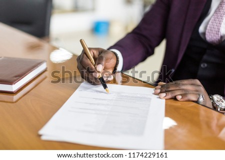 African american man signing contract, black man hand putting signature on official document, biracial clients customers couple make purchase or sign prenuptial agreement concept. clouse up