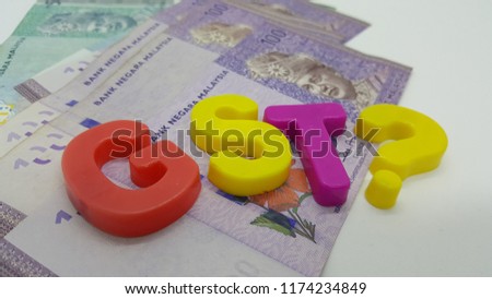 Government Service Tax concept. Money on white background with GST alphabet letters and question mark