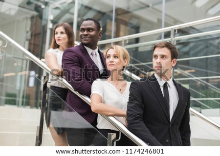 young businessmen go down the stairs and communicate. African American man and European woman