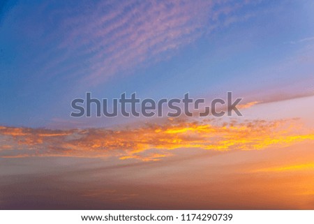 Golden clouds at sunset illuminated by the sun against the blue sky