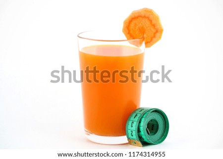 carrot juice in a glass stands on a white background