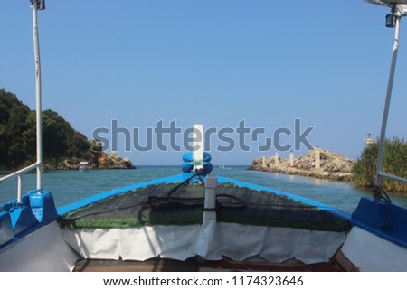 Boat with tourists in the mythical river of Acheron is about to enter the Ionian sea at the village of Ammoudia in Preveza, Greece in a sunny day with clear blue sky