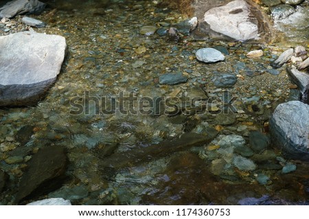 The flowing brook and river with the clear water in the countryside
