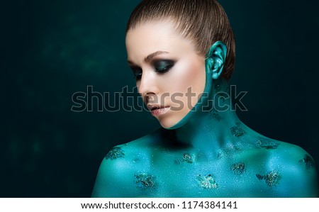 attractive model with creative makeup. The skin is painted in pearl-turquoise paint. Beautiful beauty portrait