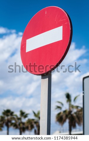 prohibiting road sign on the background of cloudy sky and palm trees