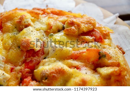 A quarter of the Tomato Chicken Pizza with many cheese.