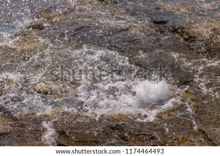 Sea water splash on rocky wet surface
