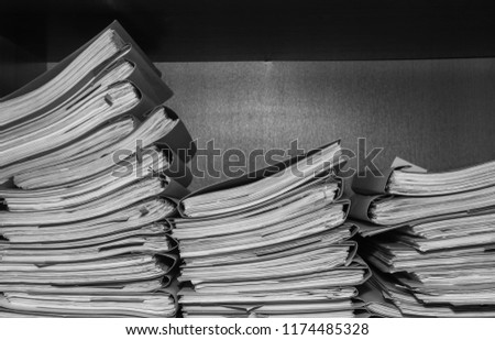 Paper documents stacked in archive. Documents on the shelves of archive room. Office shelves in the closet full of files. black and white photo