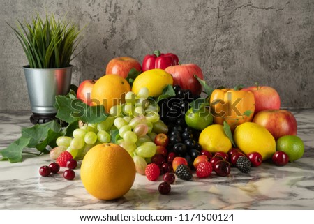 Still life of variery of fruits, oranges, grapes, strawberry, apples berries, cherry, lime and lemons on marble floor