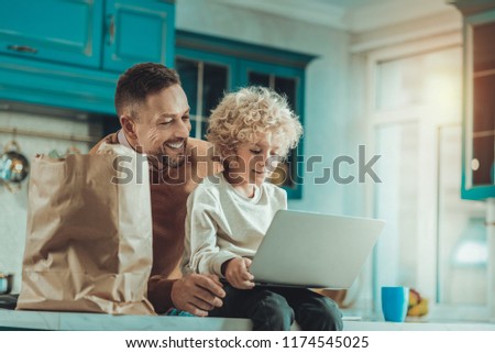 Cheerful father and son spending time together while watching a cartoon