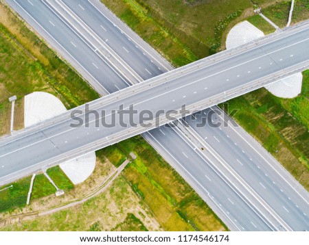 Aerial view of highway in city. Cars crossing interchange overpass. Highway interchange with traffic. Aerial bird's eye photo of highway. Expressway. Road junctions. Car passing. Top view from above. 