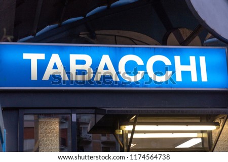 Blue signage of a Tabacchi, Italian for Tobacco shop, on a black background. Also called a tobacco shop, a tobacconist's shop or a smoke shop, it is a retailer of tobacco products