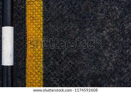Old grunge and rusty black iron plate of steel floor with yellow line seamless background and texture.