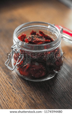 Sun dried tomatoes in glass on wooden table