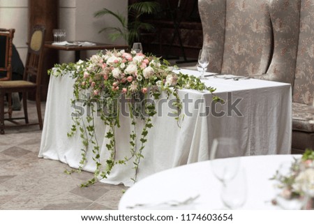 Festive table with white tablecloth and flowers on the wedding day. Table number one