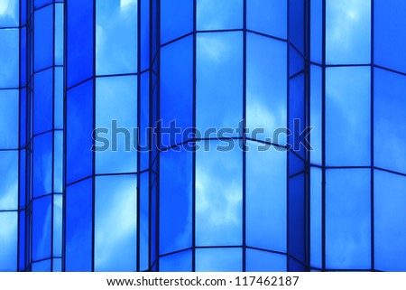 modern facade in which blue sky and clouds are reflected