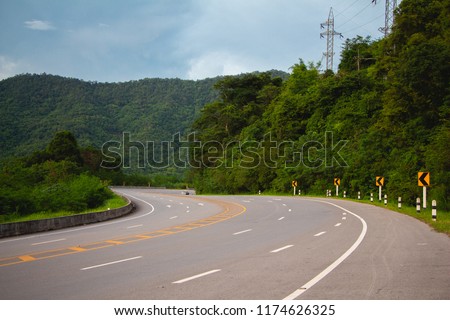 countryside road with sign curves road on the way in the mountain,