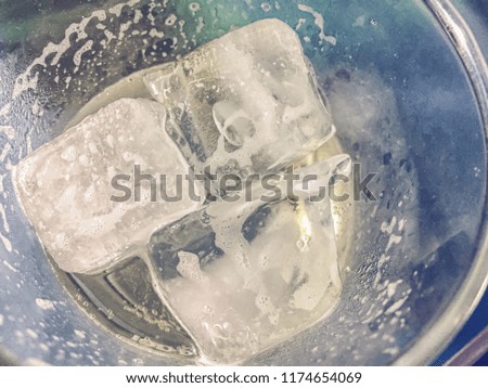 Ice cubes in an empty glass of beer. Top view close up. Texture background. Vintage picture style