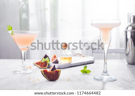 Jack Rose Cocktail with figs and honey on light background over windows